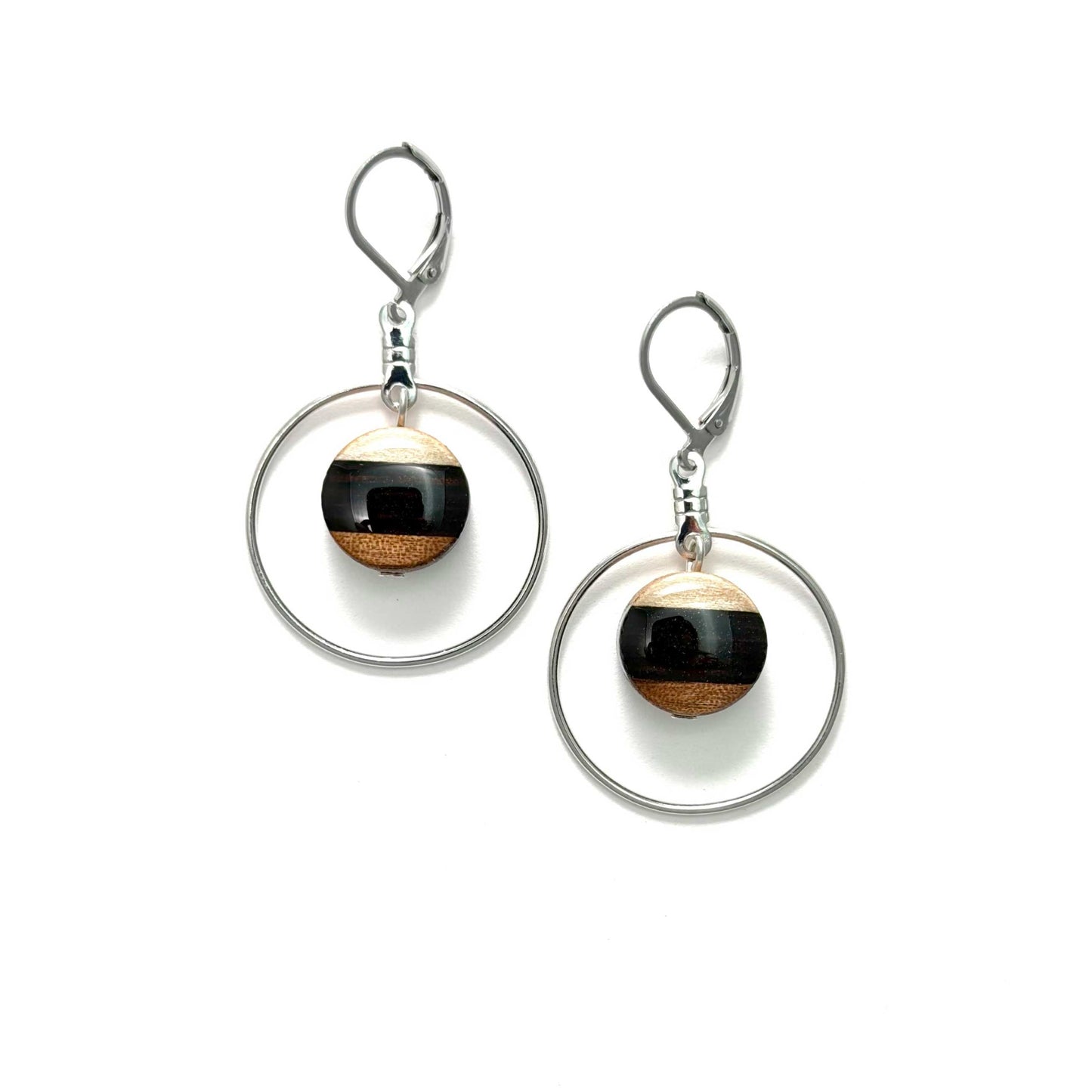 Pair of earrings with circular designs and wooden beads on a white background